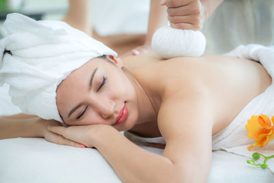 Cropped hand giving massage to woman on bed in spa