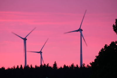 Low angle view of wind turbine against sky during sunset