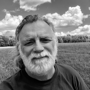 Portrait of mature man on field against sky