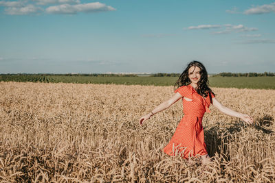 Woman standing on field against sky