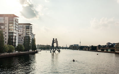 Molecule man structure in river against sky