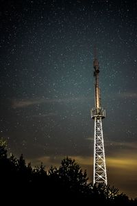 Low angle view of communications tower against sky at night