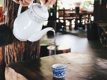 Man pouring coffee cup on table