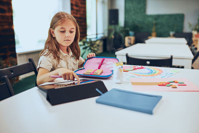 Portrait of young woman using digital tablet on table