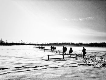 People on beach against sky