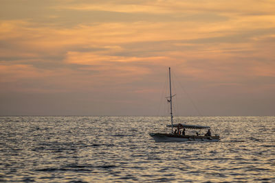 Sailboats in sea against sky during sunset