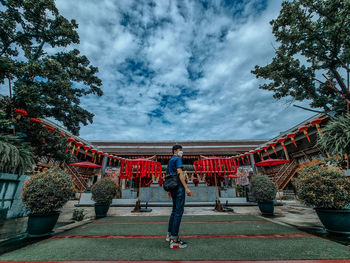 Rear view of woman with umbrella against sky