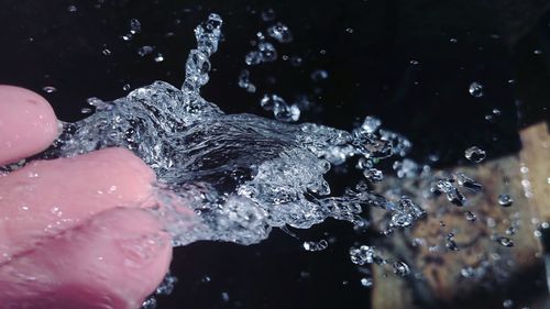 Close-up of hand splashing water