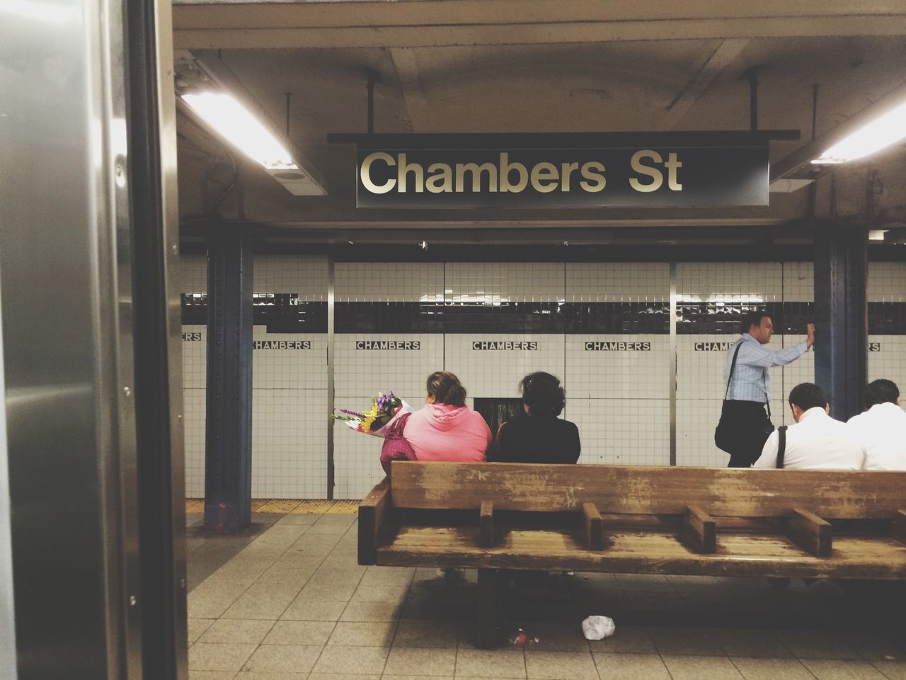 indoors, men, lifestyles, sitting, person, public transportation, leisure activity, illuminated, interior, communication, railroad station, chair, passenger, subway, full length, travel, casual clothing