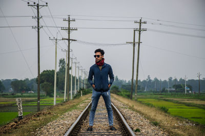 Full length of man standing on railroad track
