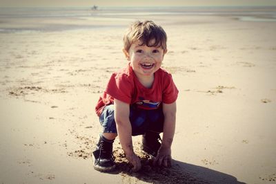 Portrait of smiling boy sitting on beach