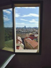 Buildings in city seen through glass window