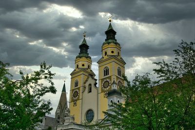 Low angle view of clock tower amidst buildings against sky