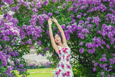 Woman standing by pink flowering plants