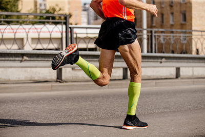 Low section of man running on street