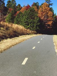 Road amidst trees against clear sky