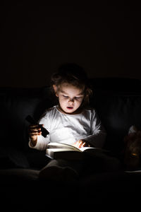 Full length of boy sitting on book