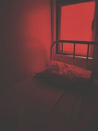 Empty red table on bed against wall at home