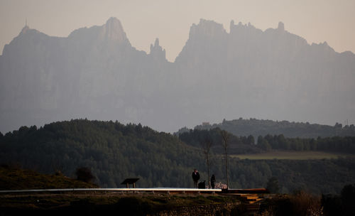 Man and woman standing against mountains 