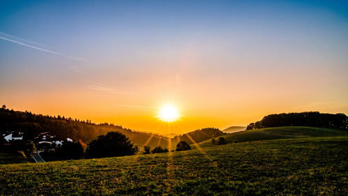 Scenic view of field against sky during sunset