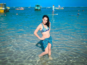 Portrait of smiling woman standing in sea