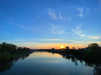 Scenic view of river against sky at sunset