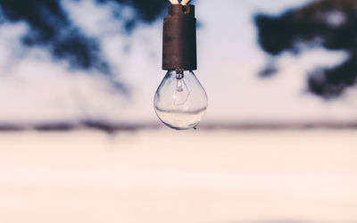 Close-up of old light bulb hanging outdoors