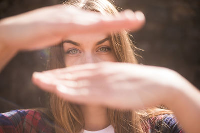 Portrait of beautiful young woman gesturing during sunny day