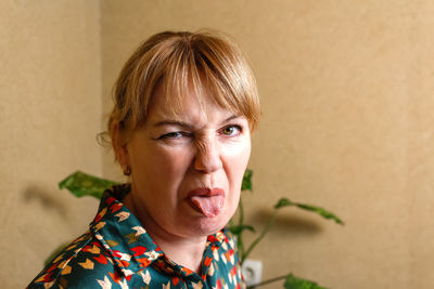 Woman procrastinate at home workplace. playful woman sticking out tongue in office. funny face 