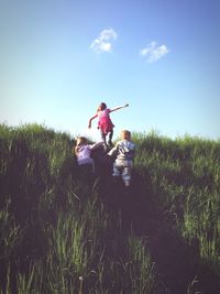 Rear view of woman standing on grassy landscape