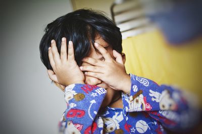 Portrait of woman covering face with hand