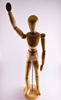 Close-up of figurine with toy against white background