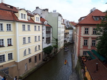 Canal amidst buildings in city against sky