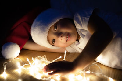 Portrait of cute boy lying on bed at home