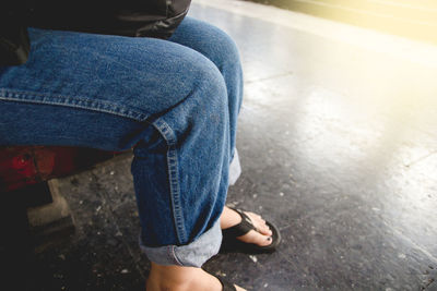 Low section of woman sitting outdoors