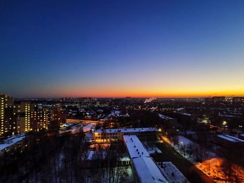 High angle view of illuminated buildings against clear sky at sunset