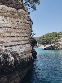 Rock formations in sea against clear sky