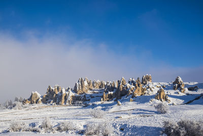 Panoramic view of frozen landscape against blue sky