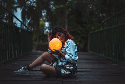 Portrait of woman sitting on footbridge