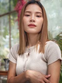 Portrait of a beautiful young woman,asian girl, cross arm looking down with blurred green background