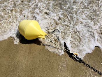 High angle view of yellow ring on beach