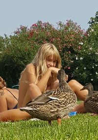 Rear view of woman relaxing on field