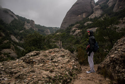 Side view of man standing against mountains