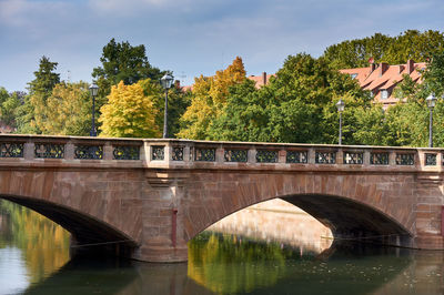 Arch bridge over river against sky