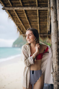 Smiling young woman standing on beach