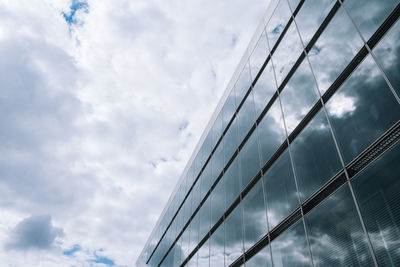 Low angle view of modern building against cloudy sky