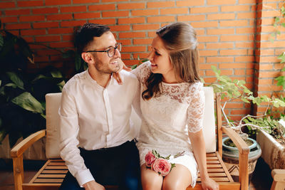 Young couple kissing against brick wall