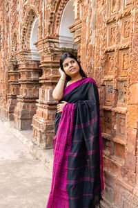 A pretty indian woman in saree near a terracotta temple of west bengal