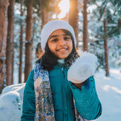 Portrait of young woman standing in forest. the joy of the winter.