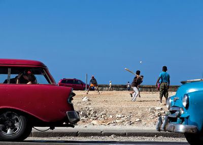 People working on motorcycle against clear blue sky